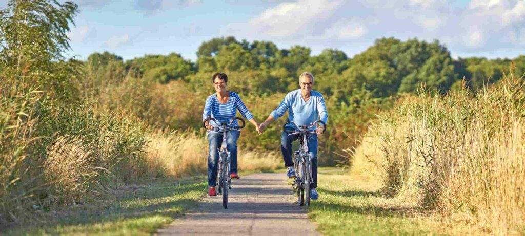 Senior couple cycling outdoors, representing active wellness at Wellness Center Ellenton.